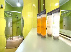 a bathroom with a row of shampoo bottles on a counter at Alpine Cottage w. Mountain View in Buşteni