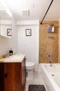 een badkamer met een toilet, een wastafel en een bad bij Modern Elegance Stylish Retreat Convention Center in Washington