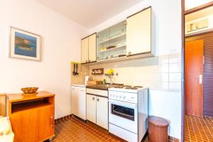 eine Küche mit weißen Schränken und einem Herd in der Unterkunft Studio Apartment Georgina in Novalja