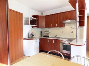a kitchen with wooden cabinets and white appliances at Apartament pod Doliną - 1,5km. od Krupówek in Zakopane