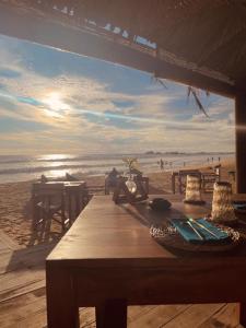 una mesa de madera en la playa con el océano en Hotel Apollo, en Hikkaduwa