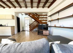 a living room with a couch and a television at Alpine Cottage w. Mountain View in Buşteni