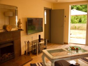 a living room with a fireplace and a table at The Walled Garden in Long Melford