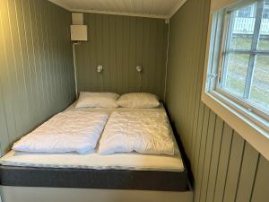 uma pequena cama num quarto com uma janela em Topcamp Rustberg - Hafjell em Hafjell