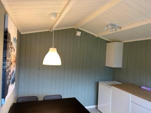 a kitchen with a table and a light hanging from the ceiling at Topcamp Rustberg - Hafjell in Hafjell