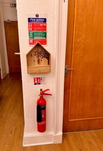 a fire extinguisher on the side of a wall next to a door at Apart Bernard Rooms in Edinburgh