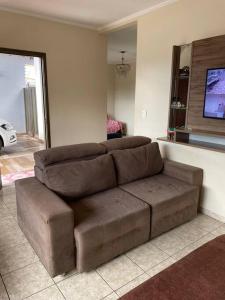 Casa completa com 4 quartos في كامبو غراندي: أريكة بنية في غرفة المعيشة مع تلفزيون