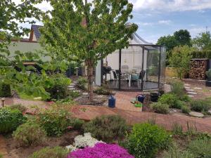 - un jardin avec un kiosque orné d'un arbre et de fleurs dans l'établissement Julia's Ferienwohnung, à Gallin