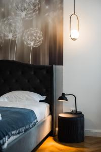 a bedroom with a bed with a headboard and a lamp at Lara’s Loft in Braşov