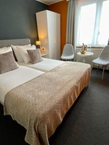 a hotel room with a large bed and a window at Hotel De la Ruïne in Valkenburg