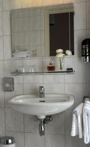 a bathroom with a sink and a mirror and towels at Hotel De la Ruïne in Valkenburg