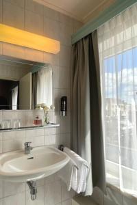 a bathroom with a sink and a window at Hotel De la Ruïne in Valkenburg