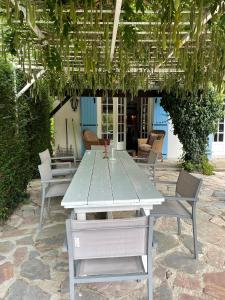a table and chairs sitting under a pergola at Le Pre du Moulin in Courniou