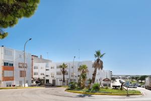 eine Straße in einer Stadt mit Palmen und Gebäuden in der Unterkunft Apartamento El Músico in Barbate