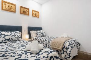 2 camas en una habitación con paredes blancas en Apartamento El Músico en Barbate
