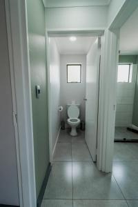 a bathroom with a white toilet in a hallway at Emerald Resort & Casino in Vanderbijlpark