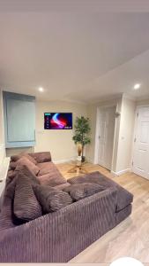 um sofá grande numa sala de estar com uma televisão de ecrã plano em Relaxing double rooms in a beautiful house em Ipswich