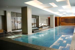 a large swimming pool in a hotel lobby at Moslem Friendly 1BR Branz BSD, Near AEON Mall & ICE in Samporo