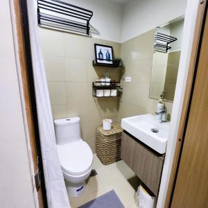 a bathroom with a toilet and a sink at My Humble Abode at Shore 3 in Manila