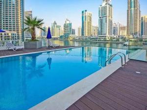 ドバイにあるNew apt in Dubai Marina with balcony and sea viewの市街のスカイラインを背景にした大型スイミングプール
