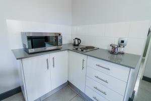 a kitchen with white cabinets and a microwave at Emerald Resort & Casino in Vanderbijlpark