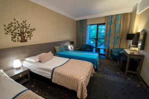 a hotel room with two beds and a desk at Hotel EUROPA - Górnicza Strzecha in Szklarska Poręba