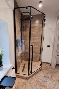 um chuveiro com uma caixa de vidro num quarto em Tuvāk Saulei em Saulkrasti