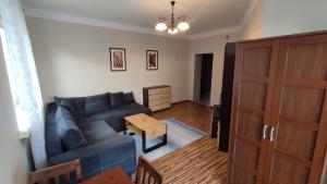 salon z niebieską kanapą i stołem w obiekcie Apartament Warszawska we Włocławku