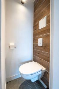 a bathroom with a toilet and a wooden wall at Secteur Gare et GEM: 2 pièces - fibre - confort + in Grenoble