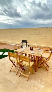 a wooden table with two chairs and a picnic table at APARTAMENTO RURAL MIRADOR DE SIERRA BERMEJA in Mirandilla