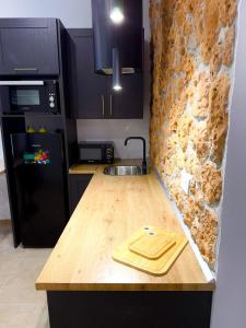a kitchen with a wooden counter and a black refrigerator at APARTAMENTO RURAL MIRADOR DE SIERRA BERMEJA in Mirandilla