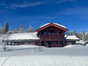 eine Blockhütte mit Schnee darauf in der Unterkunft Sollia in Lifjell