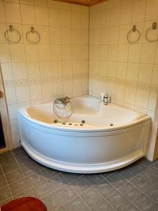 baño con bañera blanca grande y azulejos en Sollia, en Lifjell