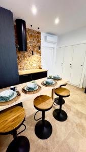 a kitchen with two tables and two stools at APARTAMENTO RURAL MIRADOR DE SIERRA BERMEJA in Mirandilla