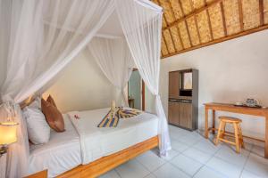 珀尼達島的住宿－Ananta Bungalow，一间卧室配有一张带天蓬的床
