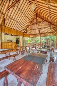 珀尼達島的住宿－Ananta Bungalow，凉亭里一张大木桌,配有长凳