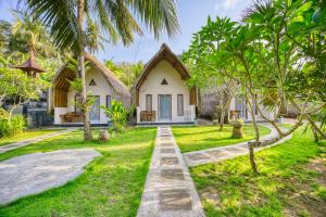una cabaña en medio de un patio con palmeras en Ananta Bungalow, en Nusa Penida