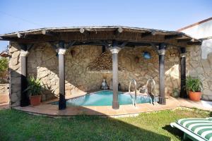 uma piscina num edifício de pedra com um gazebo em Villa Indie em Chiclana de la Frontera
