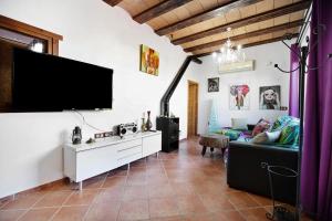 uma sala de estar com um sofá e uma televisão de ecrã plano em Villa Indie em Chiclana de la Frontera
