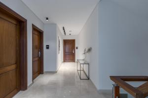 a hallway with white walls and a wooden door at Livingville Nine in Cairo