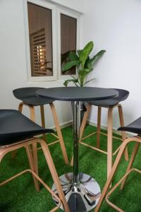una mesa y tres taburetes en una habitación en Luxurious Three-Bedroom Apartment In Wuye Abuja - New Base Apartments, en Dakibiu