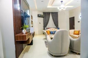 sala de estar con 2 sillas y sofá en Luxurious Three-Bedroom Apartment In Wuye Abuja - New Base Apartments, en Dakibiu
