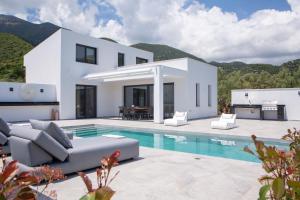 eine Villa mit einem Pool und einem Haus in der Unterkunft Eros - Afroditi Villas Collection in Nydri