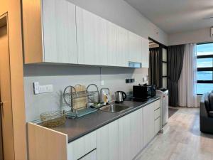 a kitchen with a sink and a counter top at CC Suites Jesselton Quay - Seaview - 2Bedroom in Kota Kinabalu