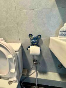 a bathroom with a toilet with a toy animal on the wall at CC Suites Jesselton Quay - Seaview - 2Bedroom in Kota Kinabalu