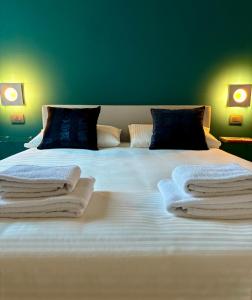 een slaapkamer met een groot bed en handdoeken bij La casa di Albert - luxury living in Milaan