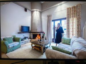 a woman standing in a living room with a fireplace at Giogarakis Suites in Eleonas