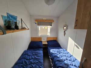 een kleine kamer met 2 bedden en een raam bij RBR 1336 - Beach Resort Kamperland in Kamperland