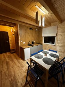 Apartamenty pod Witoszą في Staniszów: مطبخ مع طاولة وكراسي في غرفة