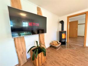 uma sala de estar com uma televisão de ecrã plano e uma lareira em BIG Apartment for YOUR DREAM Vacation Bavarian Forest + NETFLIX em Schöfweg